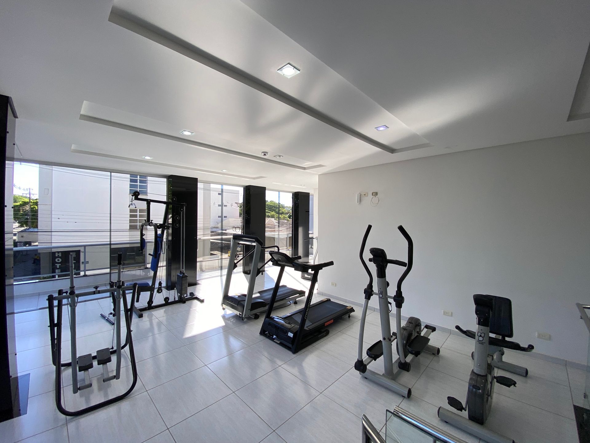 Uma academia com esteiras, elípticos e outros equipamentos de exercícios