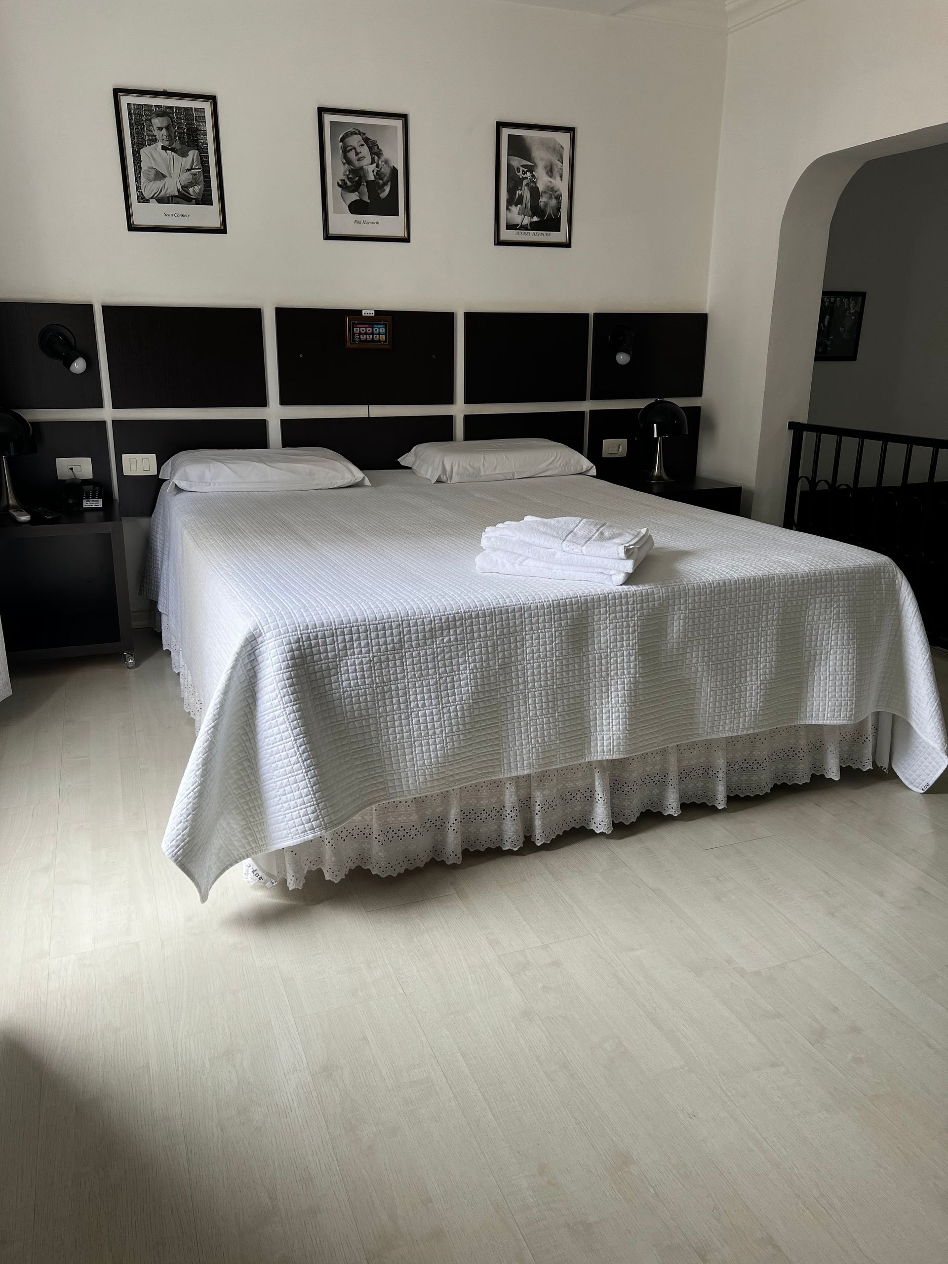 Um quarto de hotel com uma cama grande e três fotos na parede