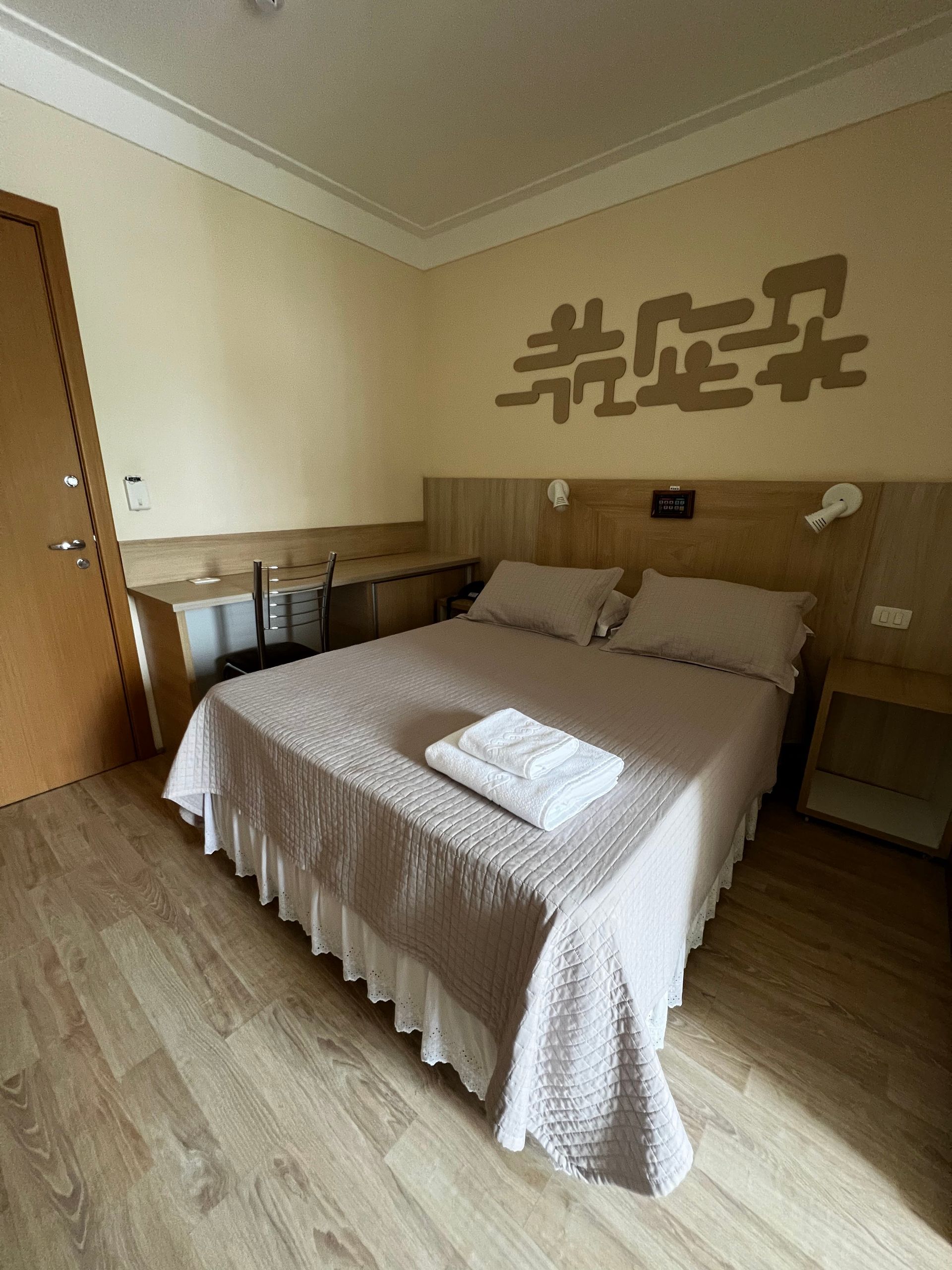Um quarto de hotel com uma cama grande e uma escrita chinesa na parede