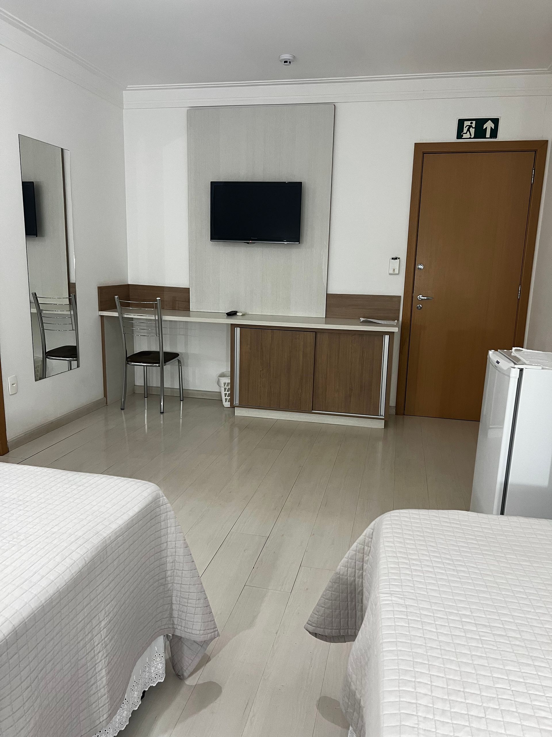 Um quarto de hotel com duas camas e uma TV de tela plana