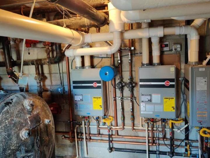 A room with a lot of pipes and boilers in it.