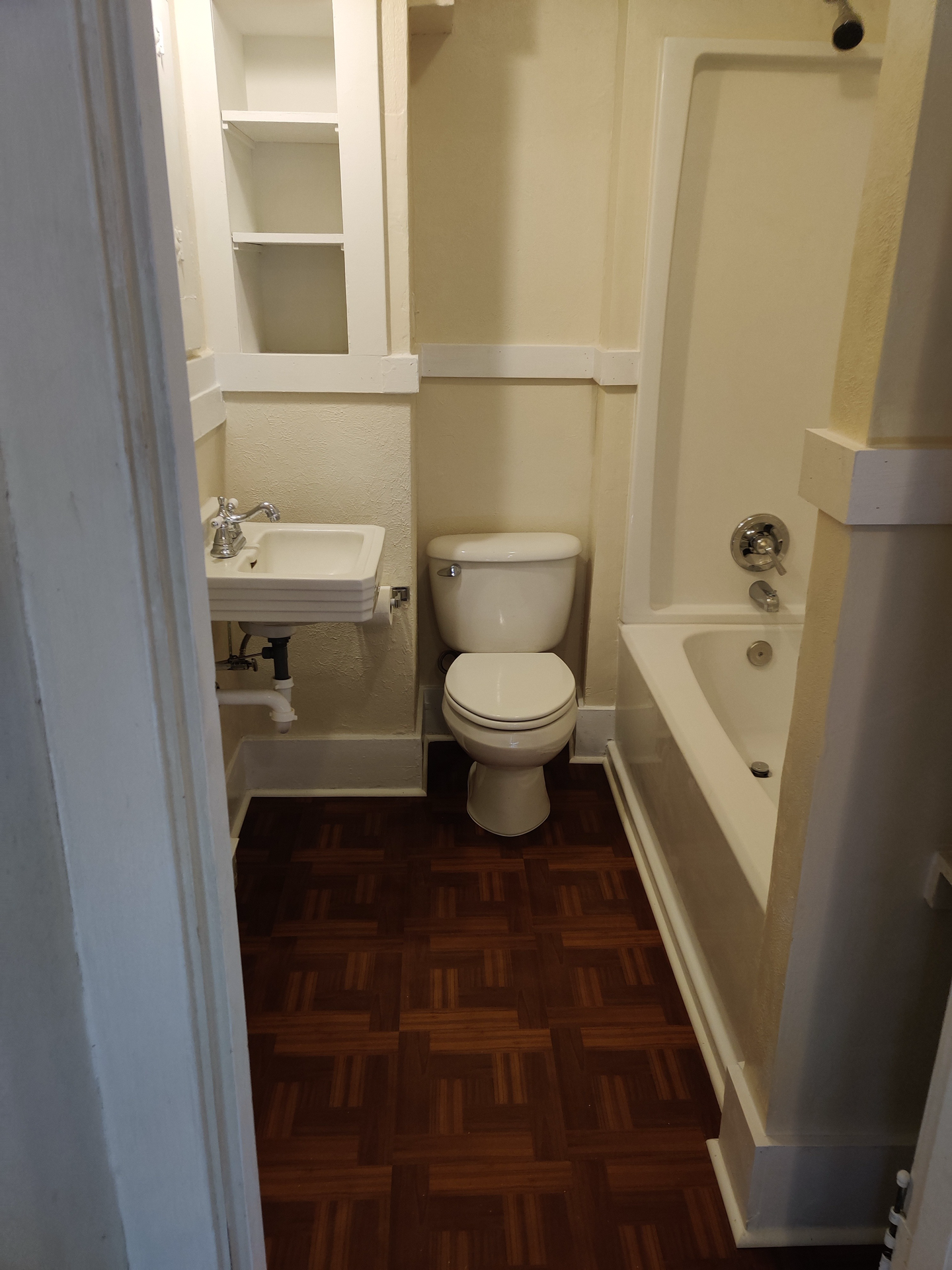 A bathroom with a sink , toilet , shower and mirror.