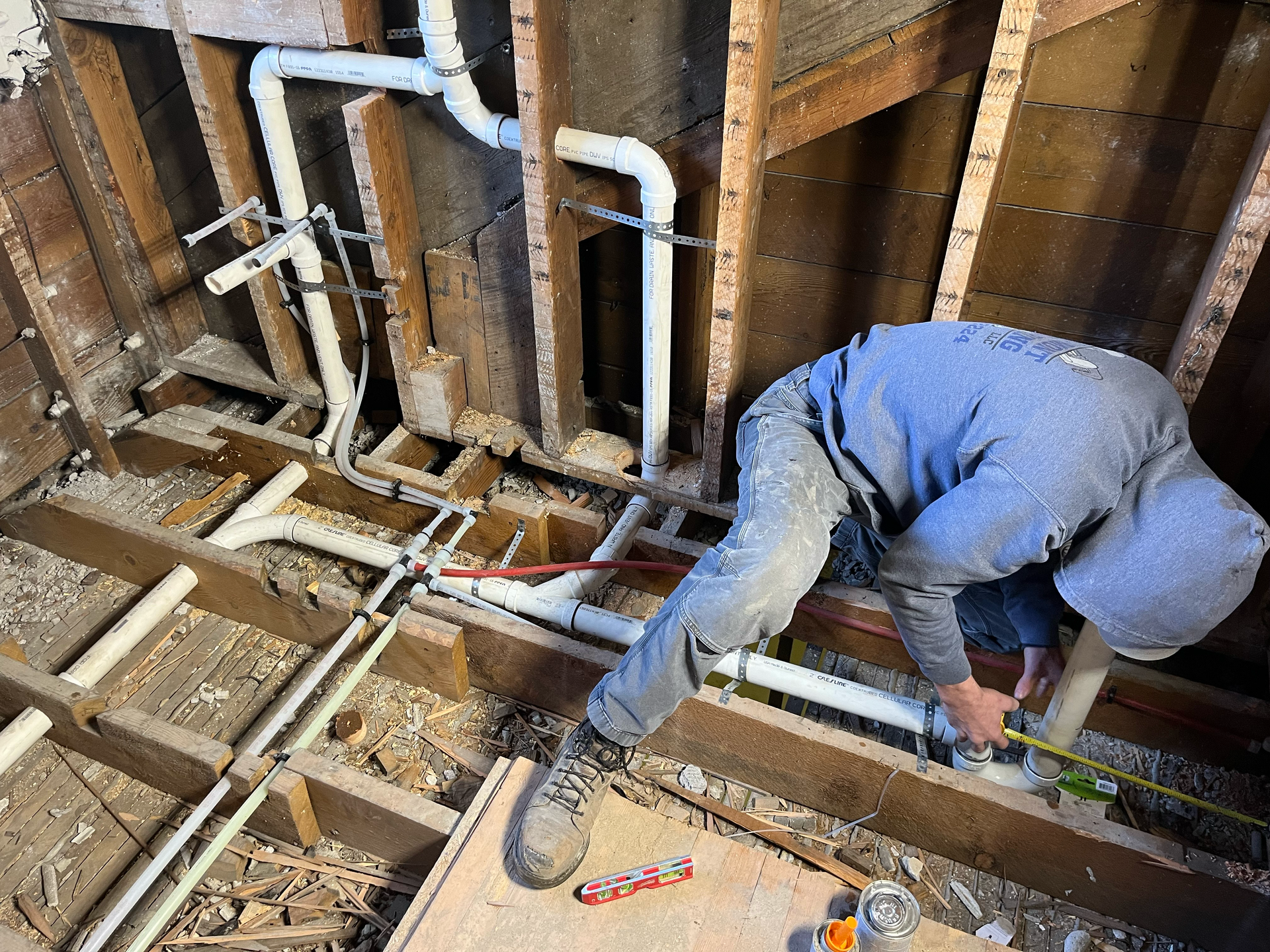 A plumber is working on a hose with a wrench.