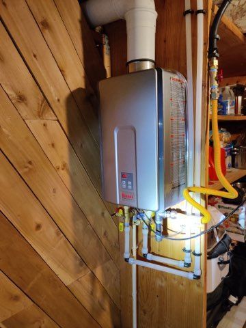 A man is fixing a water heater in a bathroom.