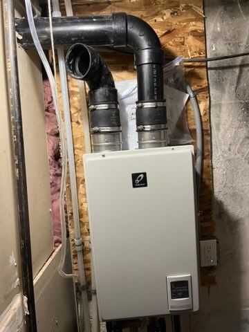 A man in a blue uniform is working on a boiler.