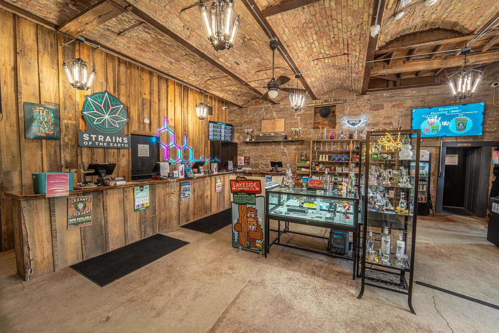 Modern bakery interior with green shelving, display counters, and a central round table.