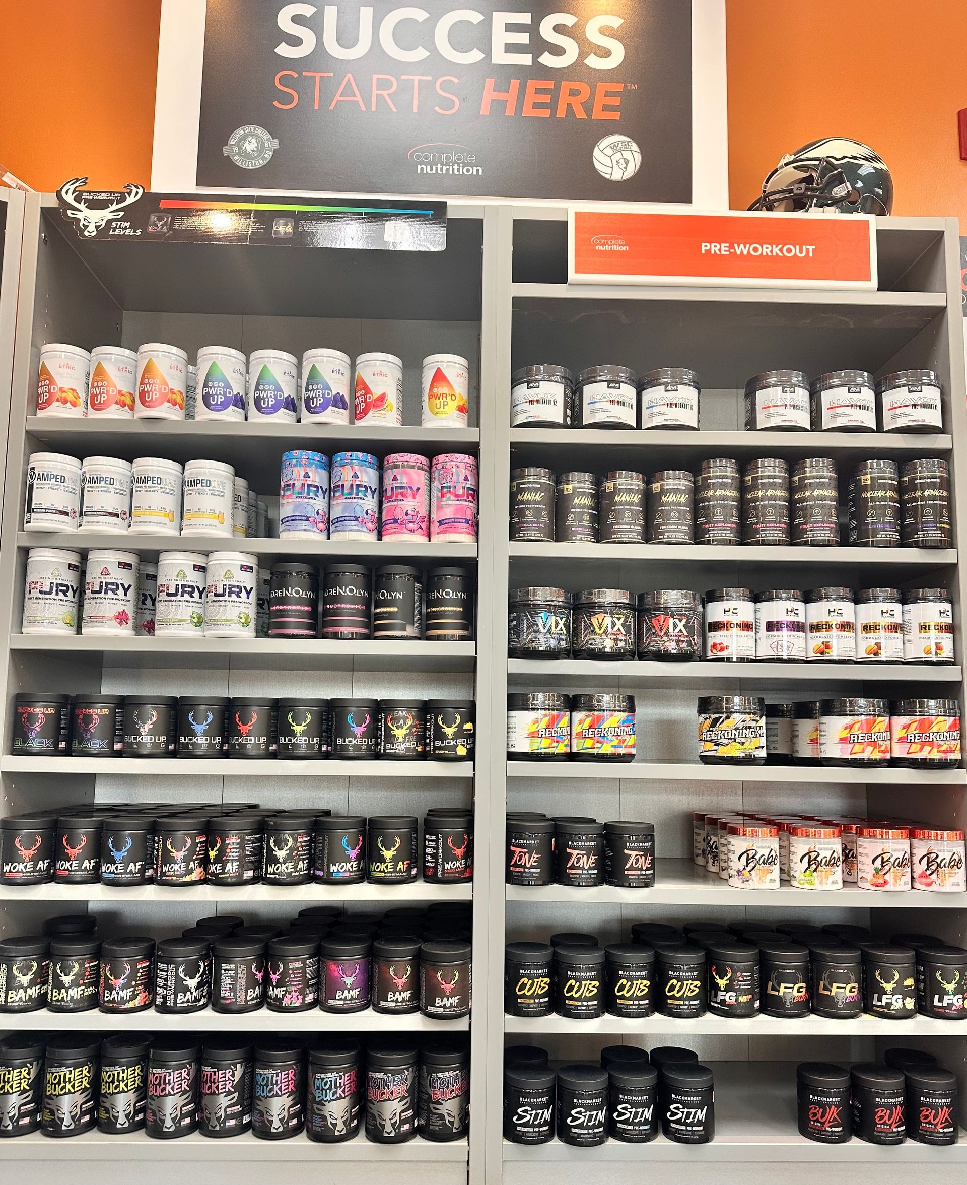 Shelves stocked with various supplement jars and cans in a store, with 