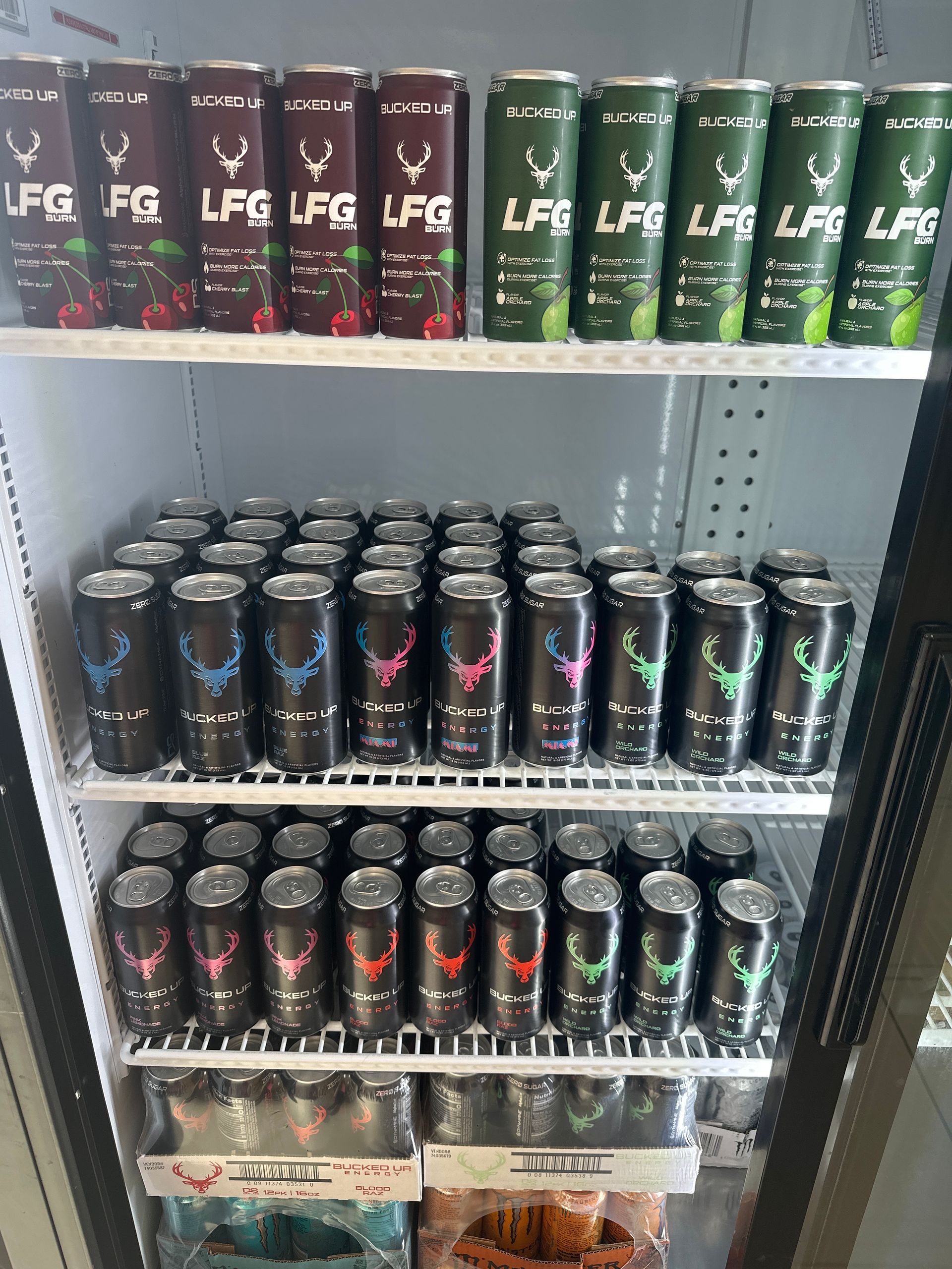 A refrigerator stocked with LFG energy drinks in various colors: cherry, mint, blue, pink, and green.