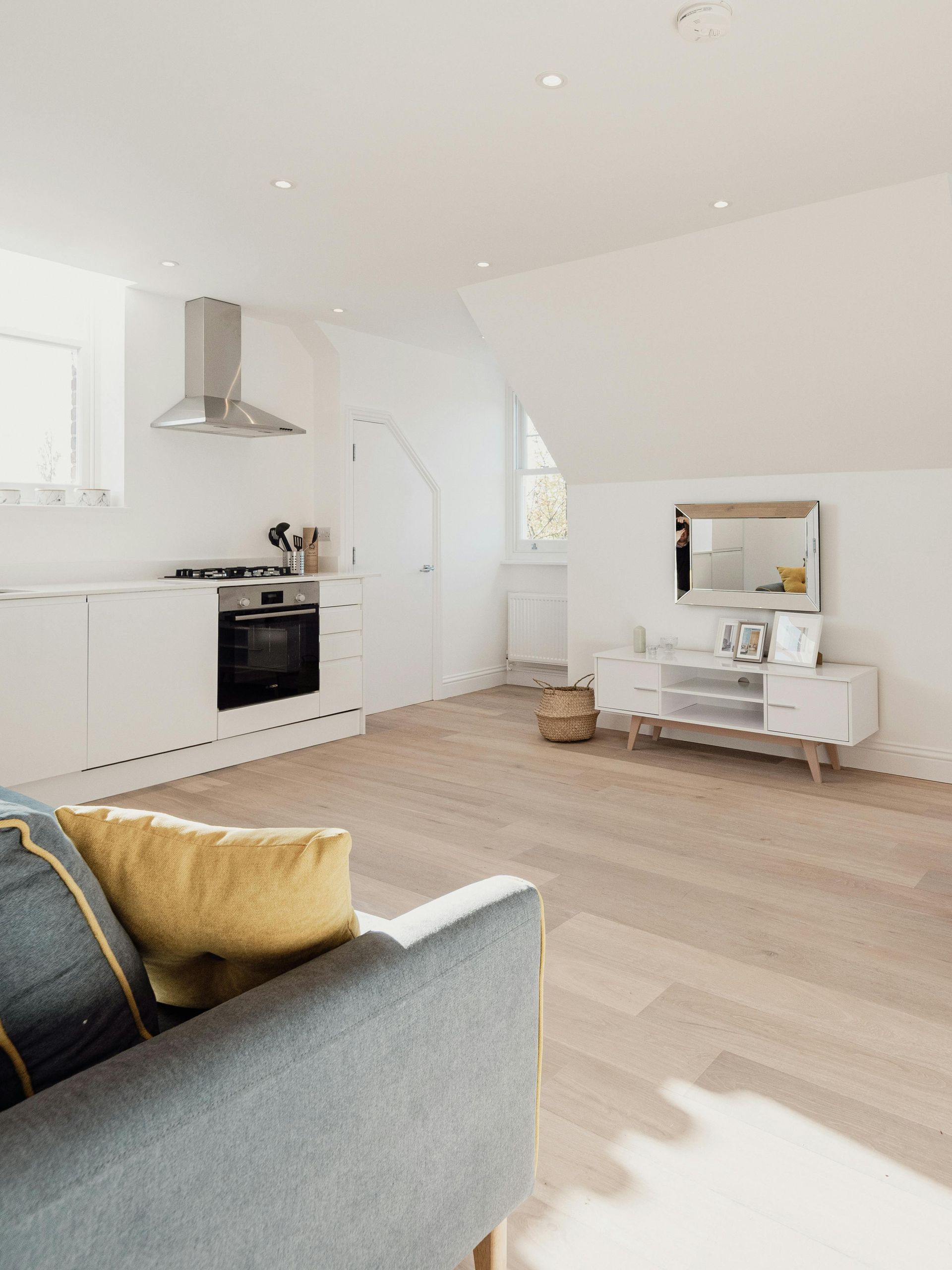 A living room with a couch and a kitchen in the background