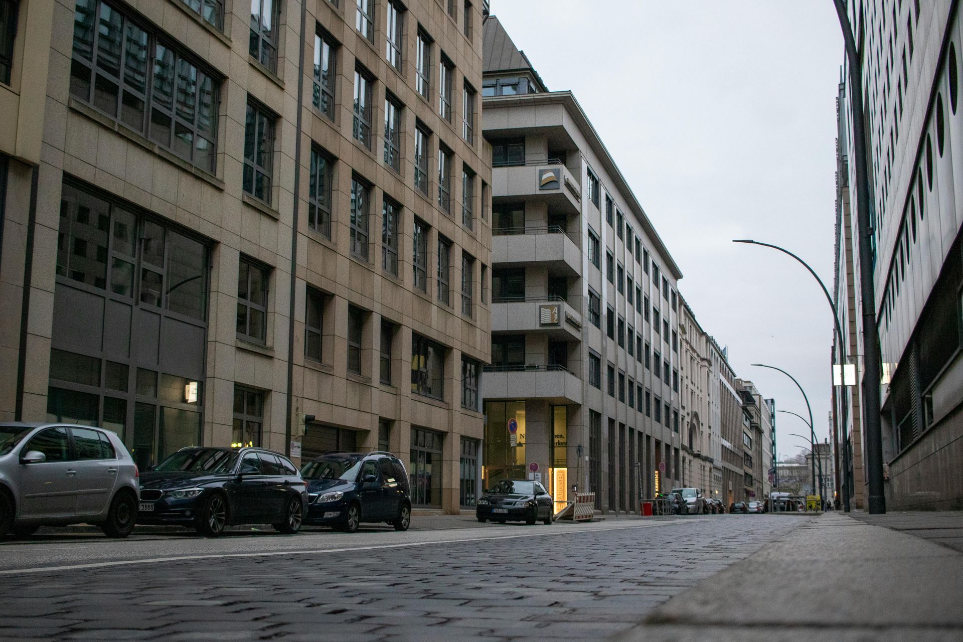 A row of buildings are lined up on a cobblestone street.