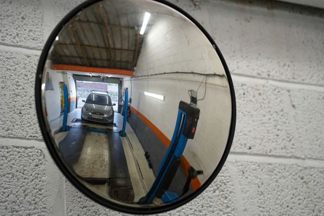 close up of an mot bay mirror showing a car been driven onto the MOT bay Ramp
