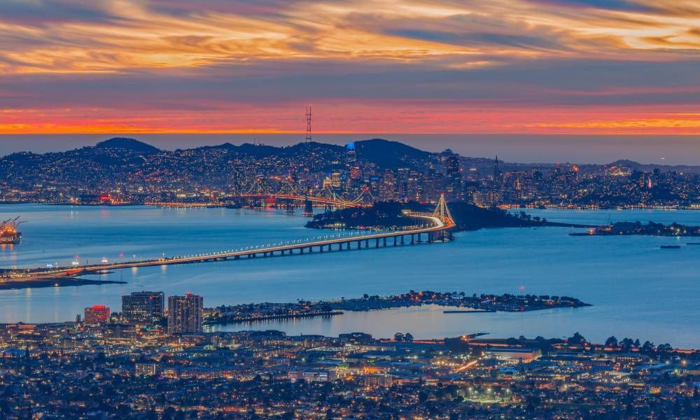 The San Francisco Bay Area during sunset with an array of vibrant oranges, pinks, and purples painting the sky