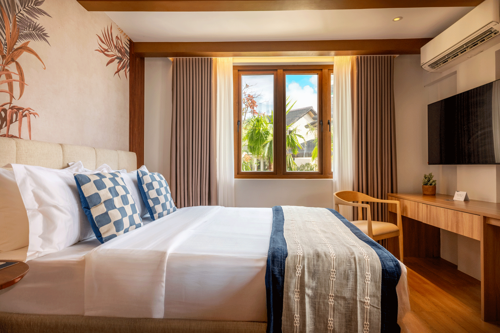Bright hotel room at Harvest Hotel Cabanatuan with tropical decor and pool 