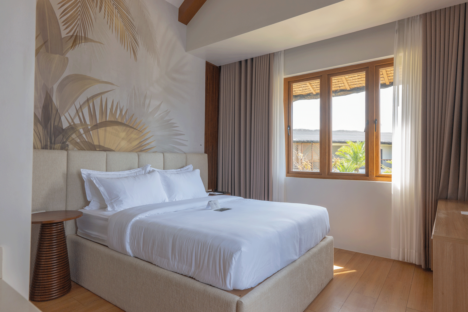 Bright tropical-themed hotel room with king bed at Harvest Hotel Cabanatuan