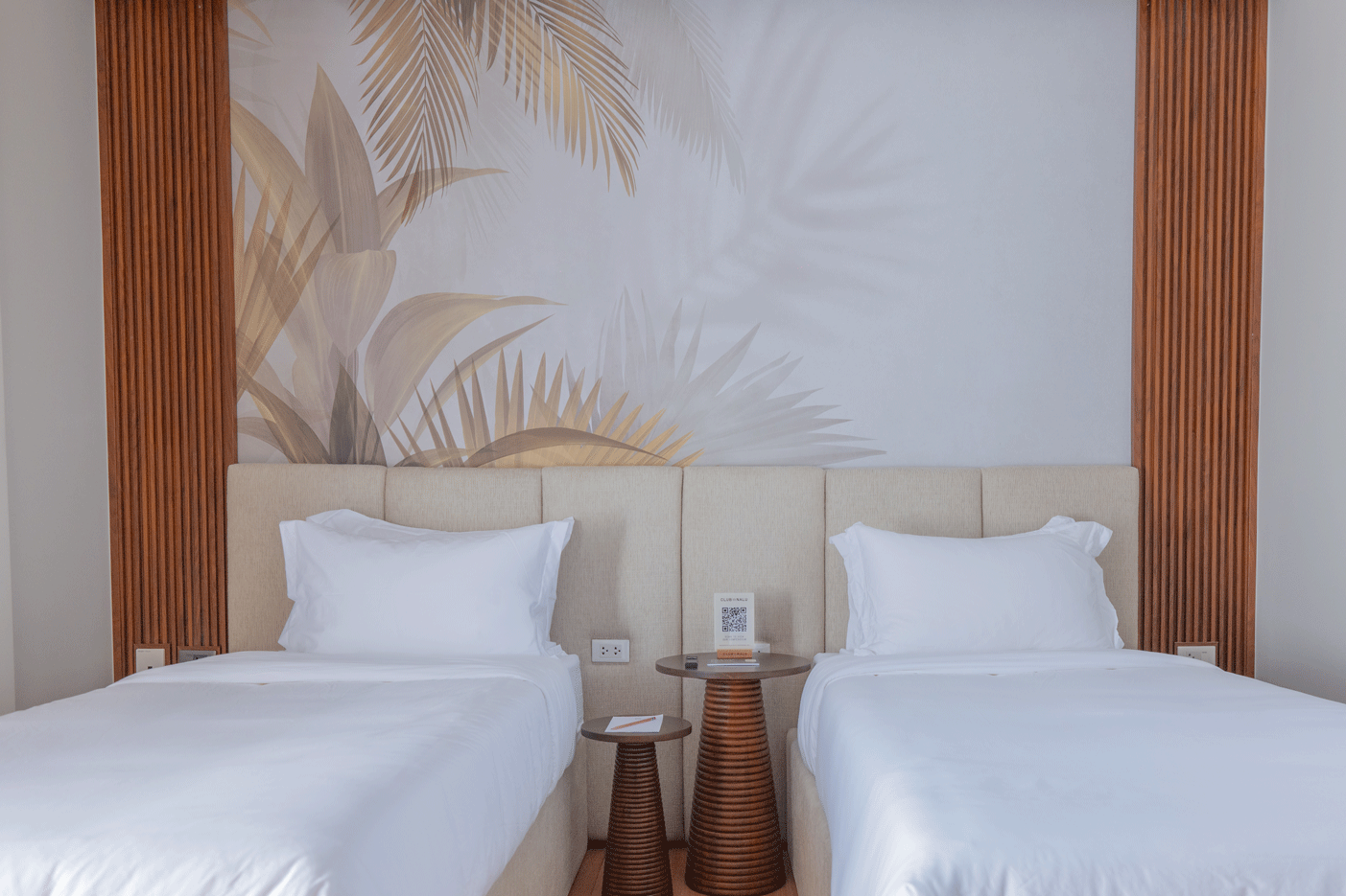Twin bed hotel room with tropical mural at Harvest Hotel Cabanatuan