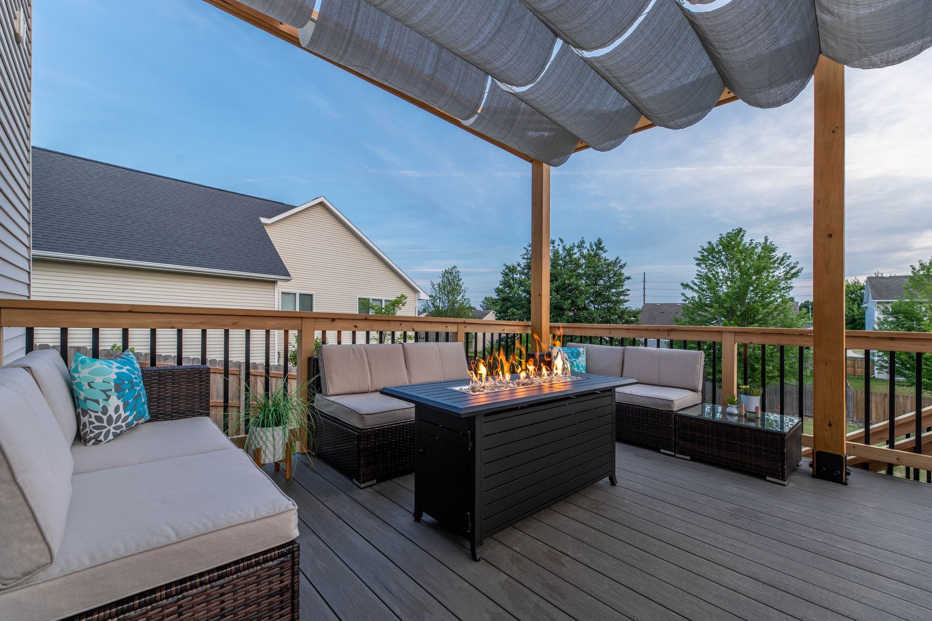 There is a fire pit on the deck with a canopy over it.