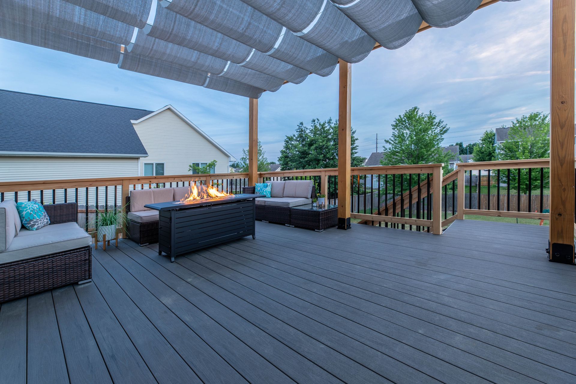 There is a fire pit on the deck with a canopy over it.