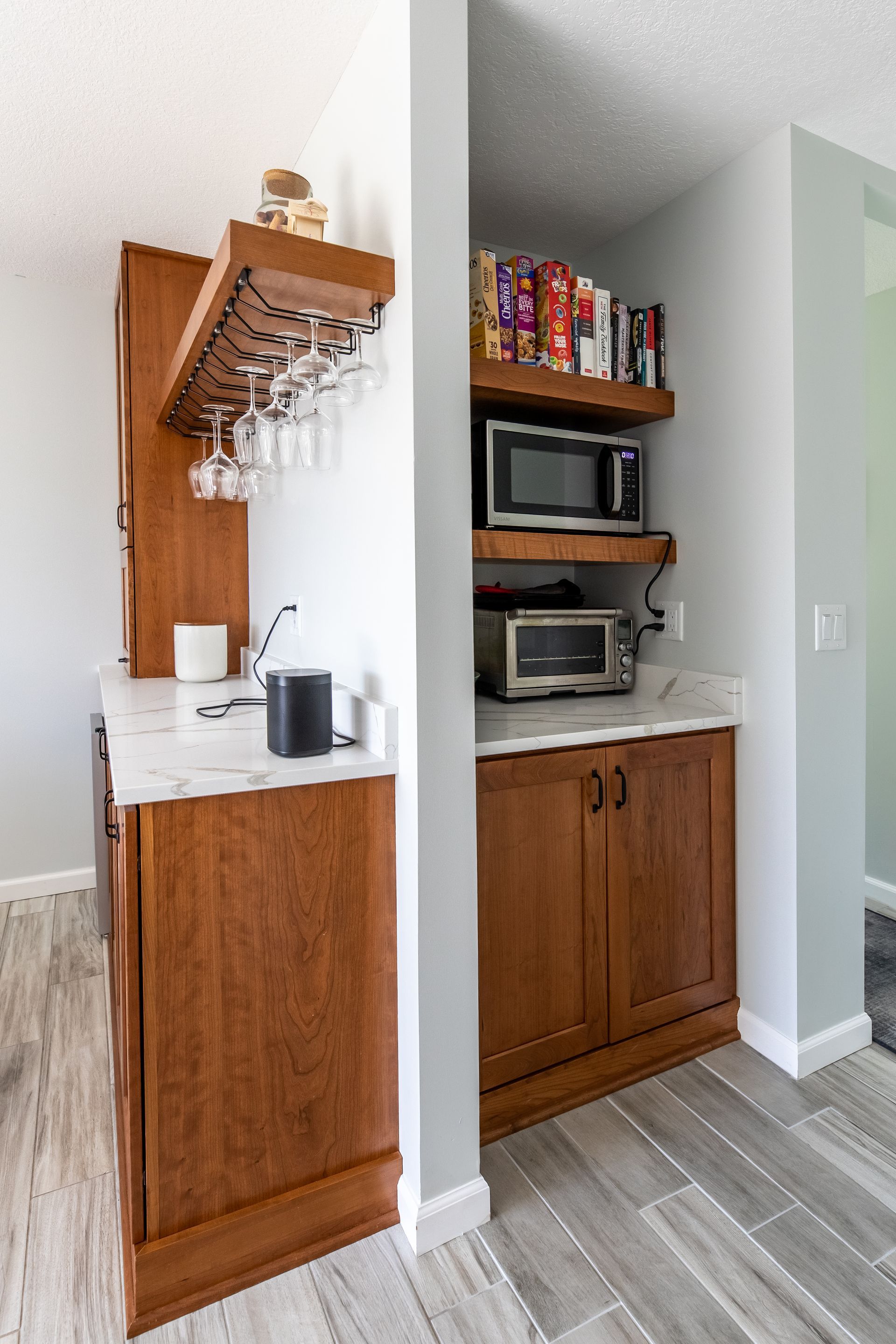 A kitchen with wooden cabinets , a microwave , and a wine rack.