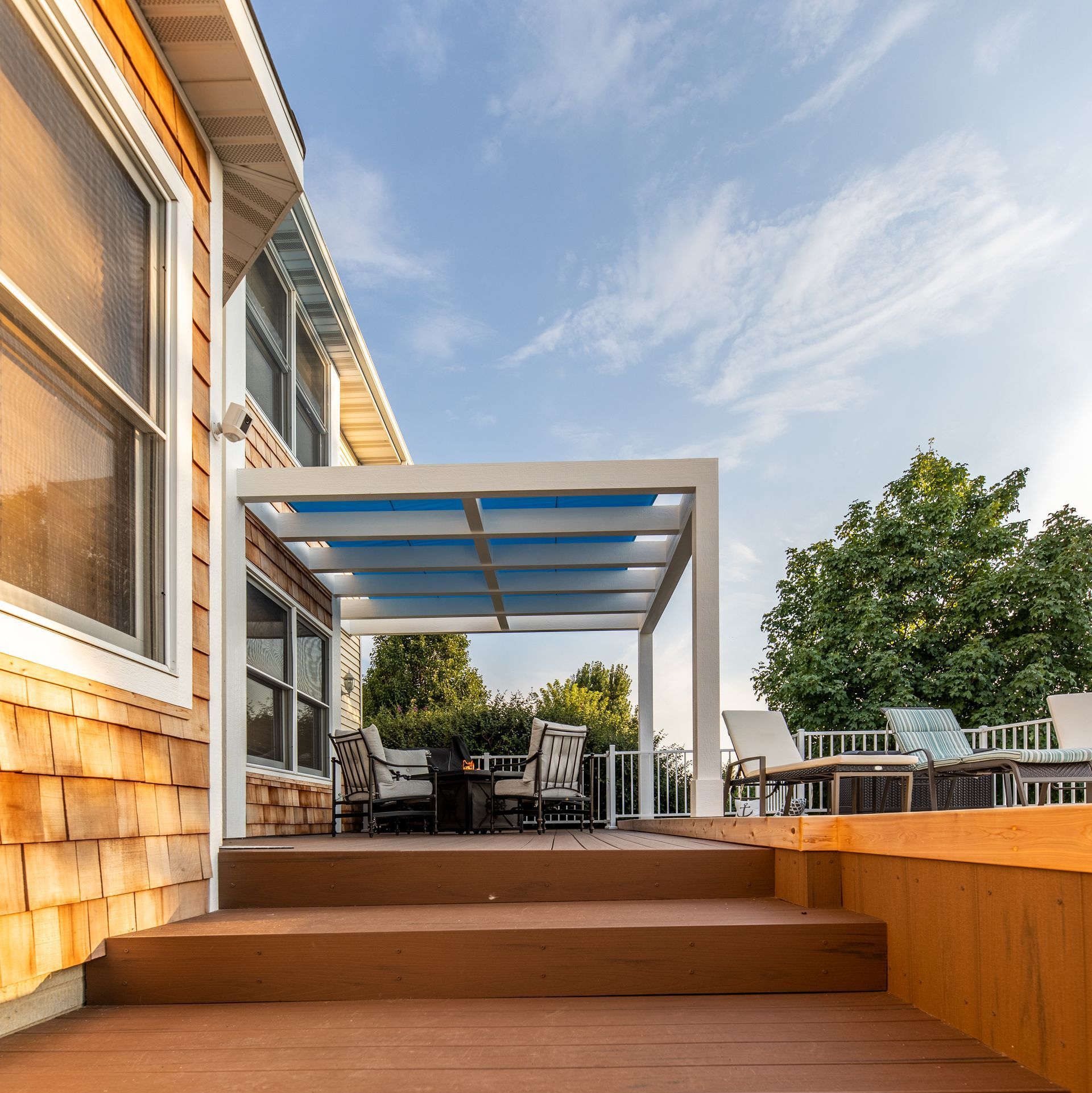 A house with a large deck with a pergola over it