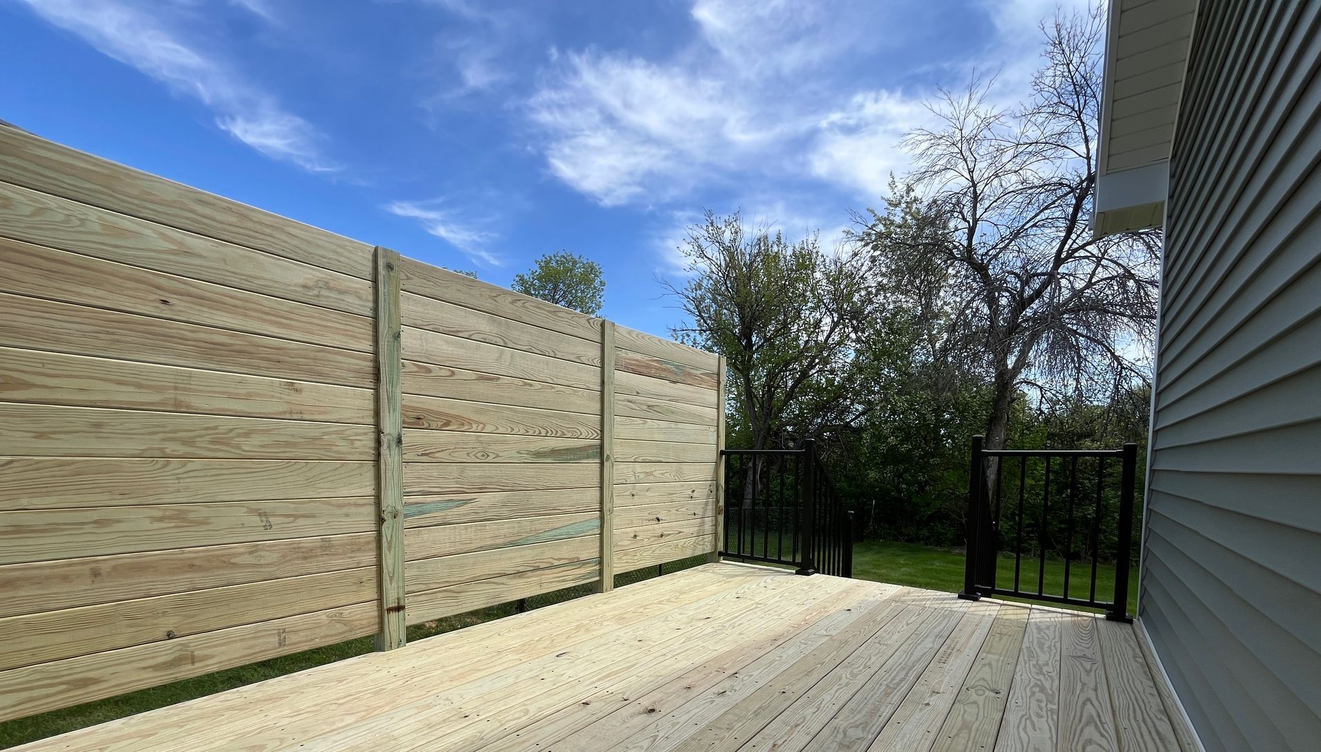 A wooden deck with a wooden fence surrounding it