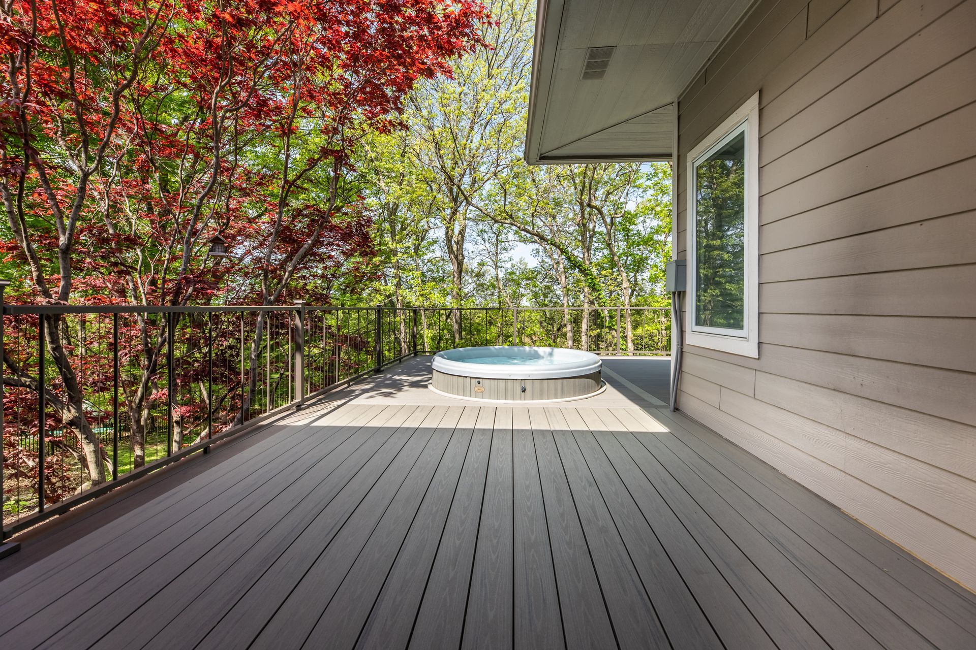 There is a hot tub on the deck of a house.