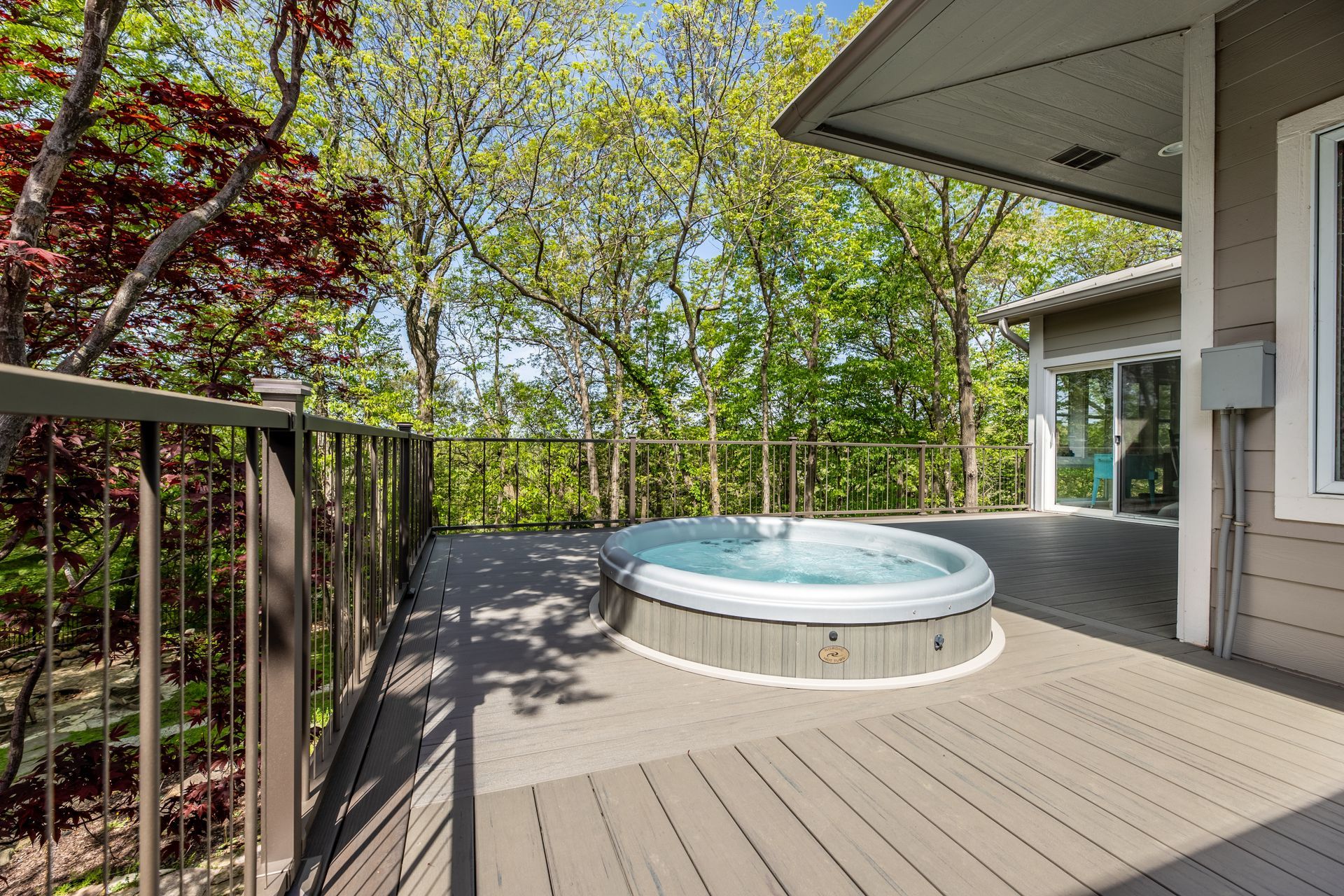There is a hot tub on the deck of a house.
