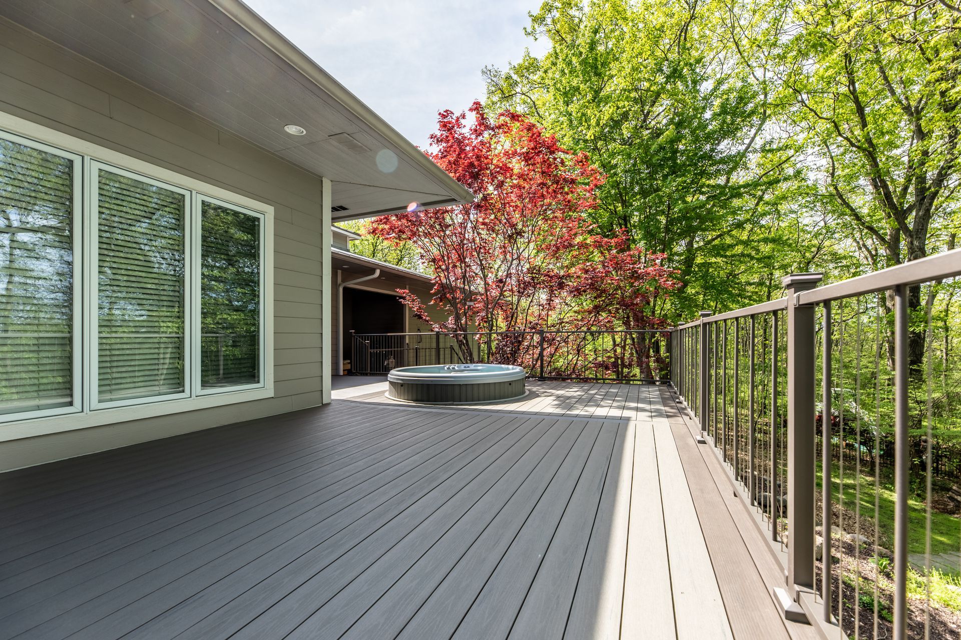 There is a hot tub on the deck of a house.