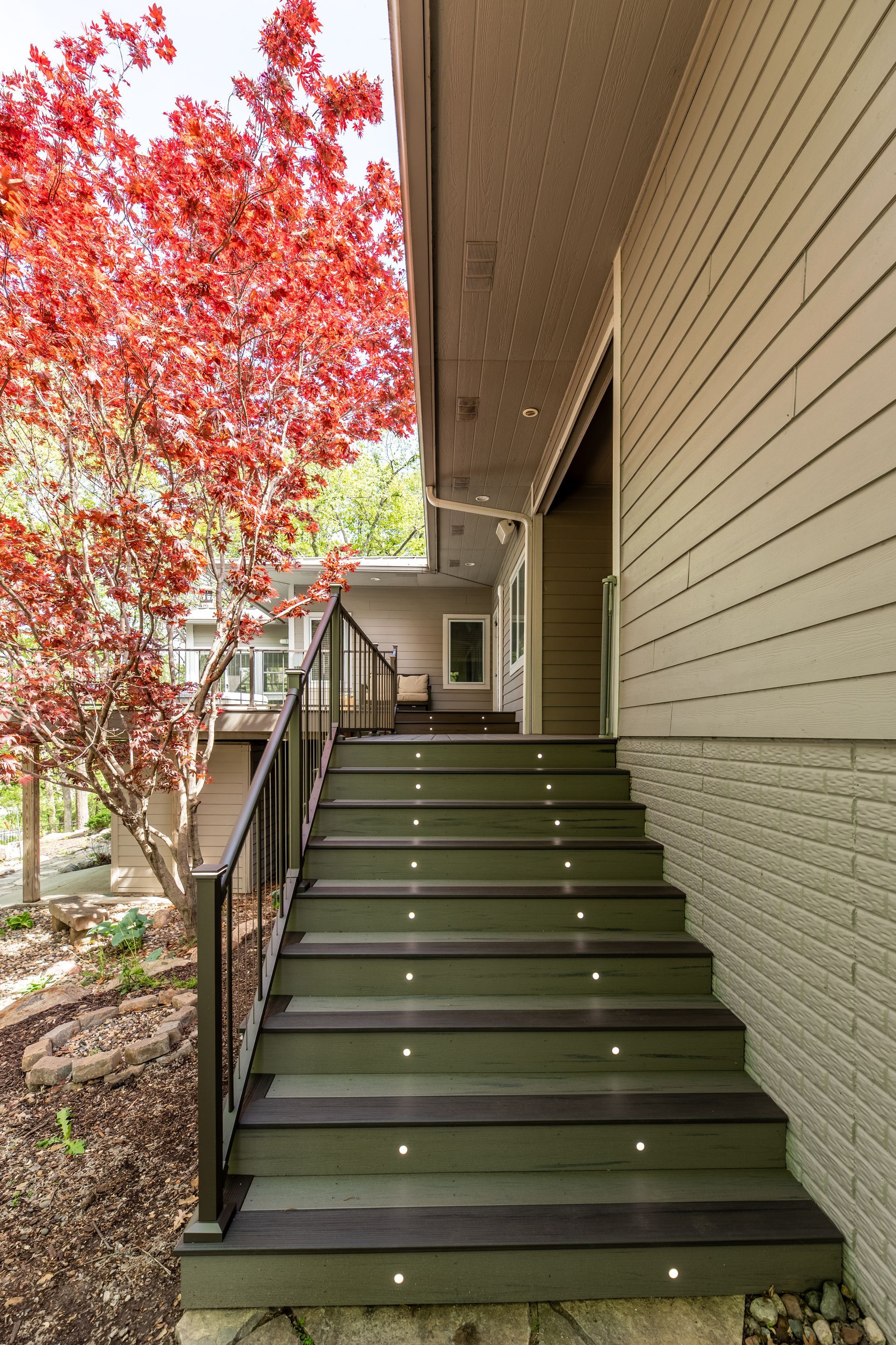 A set of stairs leading up to a house with a tree in the background.