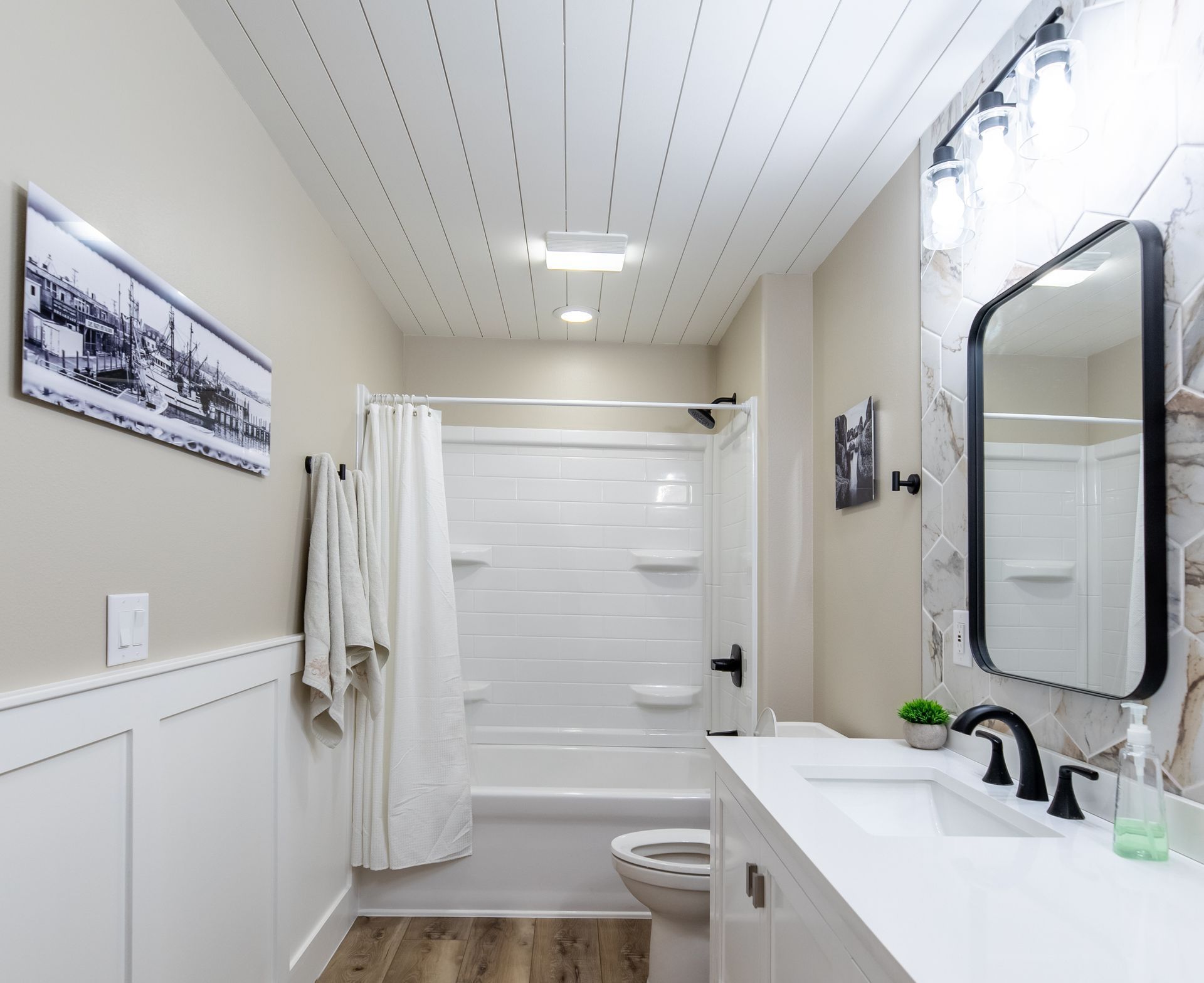 A newly remodeled bathroom with a sink , toilet , shower and mirror.