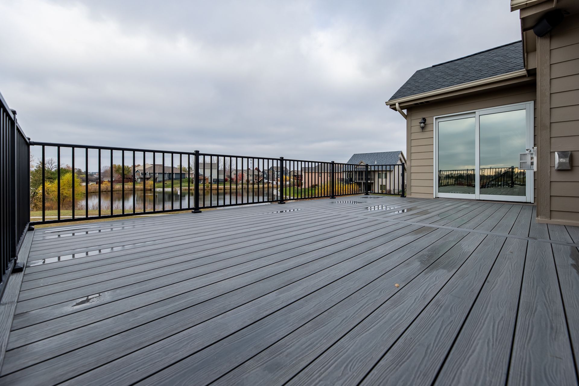 A large deck with a railing and a sliding glass door.