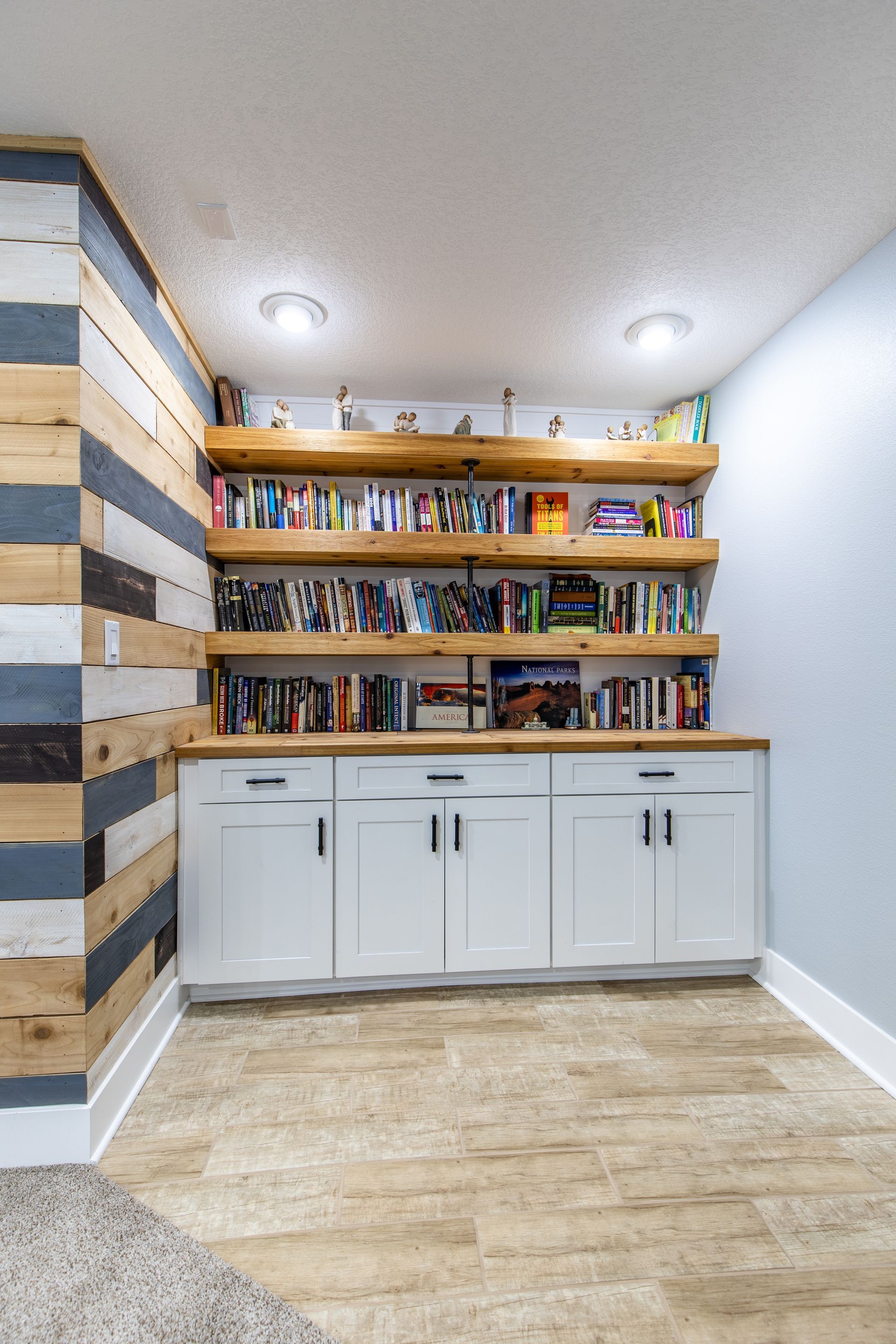 A room with a wooden wall and shelves filled with books.