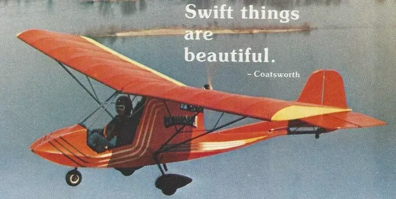 Red and yellow ultralight aircraft in flight over water. Text: 
