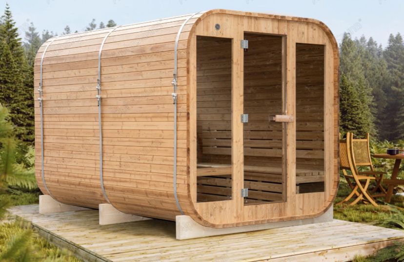 Wooden outdoor sauna cabin with glass front doors on a patio near trees