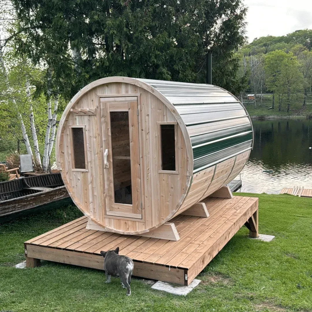 Wooden 4 person barrel-shaped outdoor sauna with glass door on a paved patio in a yard