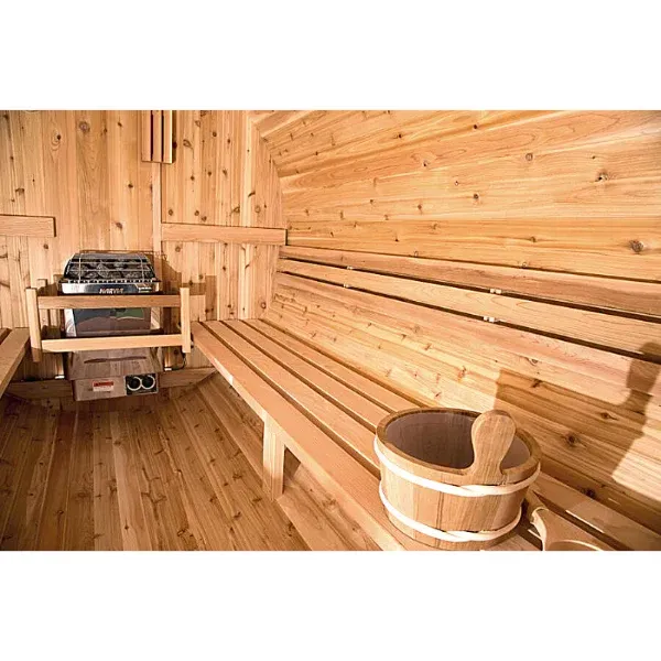 Wood-paneled sauna with long benches, a heater, and a wooden bucket and ladle on the floor