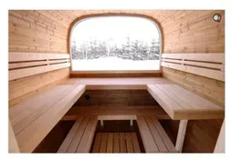 Wooden sauna interior with bench seating and a large frosted window