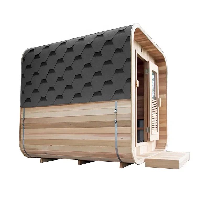 Small wooden sauna cabin with open door and step, outdoors beside a building.
