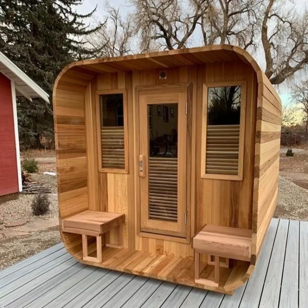 Wooden outdoor sauna cabin with front door, windows, and two benches on a deck