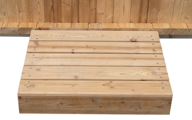 Wooden step or platform with slatted top against a wood-paneled wall