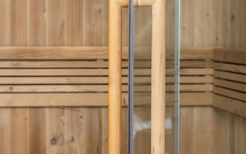 Wooden sauna interior with vertical heat gauges mounted on the wall