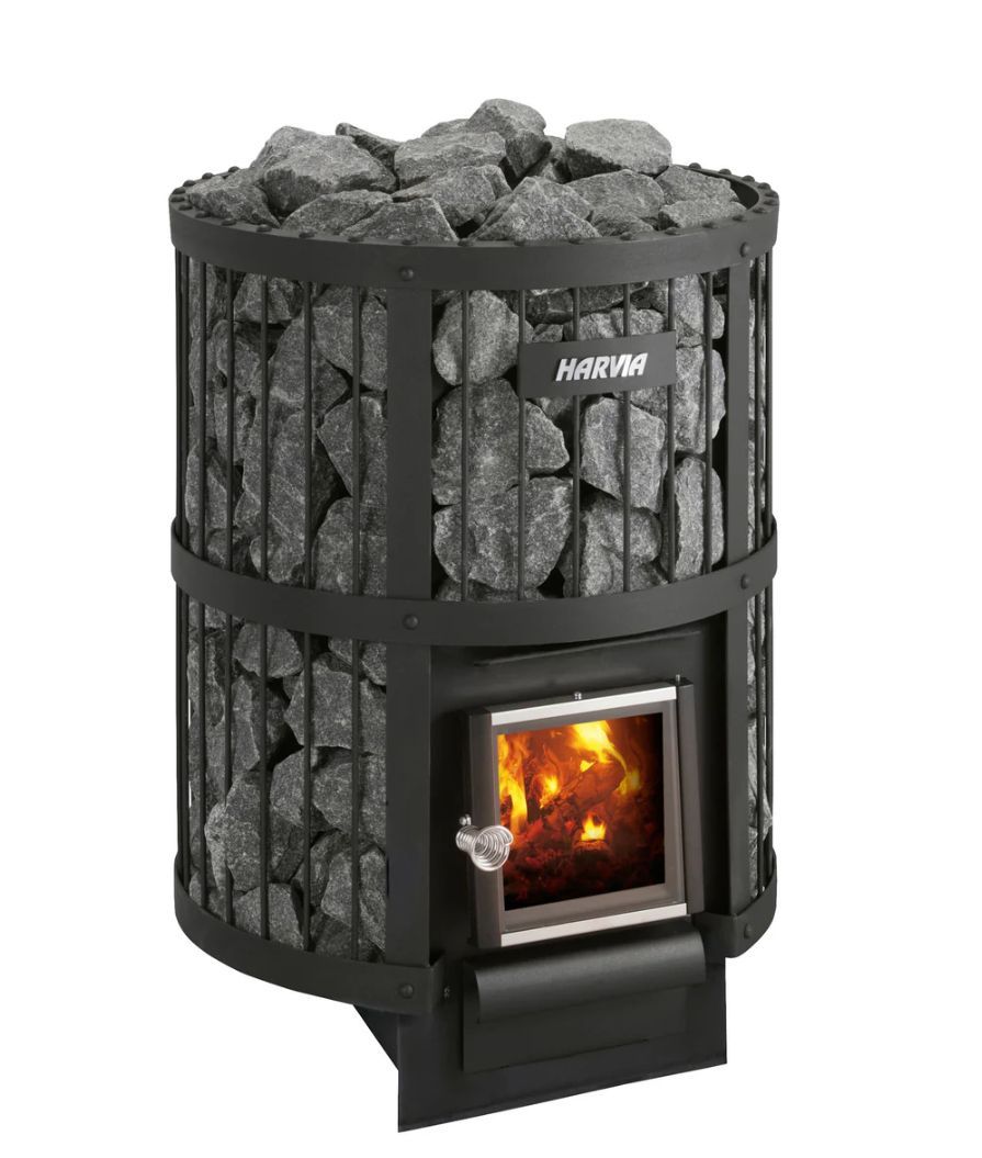 Black cylindrical sauna stove with rocks on top and a glowing firebox door.