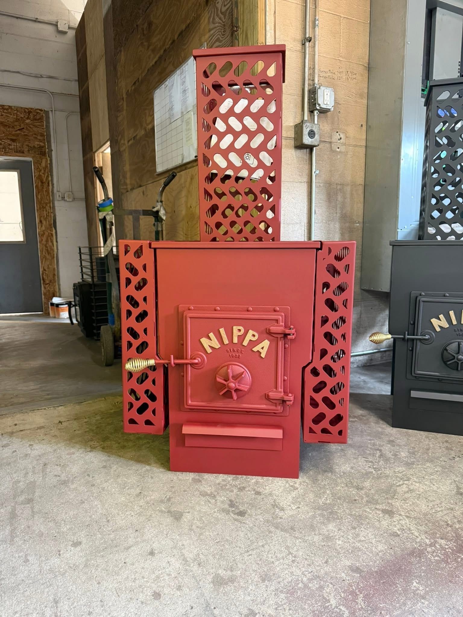 Red decorative metal cabinet with lattice sides and “NIPPA” on the front in a rustic indoor setting