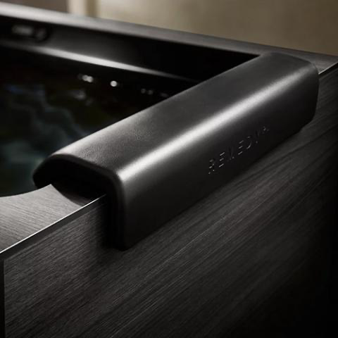 Black metal grab handle on a textured dark appliance or fixture