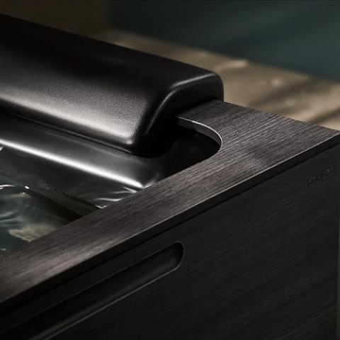 Close-up of a sleek black metal machine corner with a brushed finish and recessed handle.