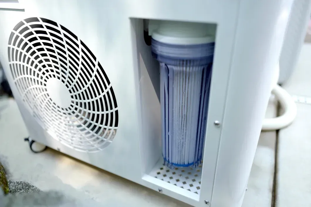 Open air filter in a white machine with a vented side panel and visible cylindrical filter cartridge