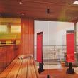 Modern sauna interior with wooden benches, red panels, and glass walls