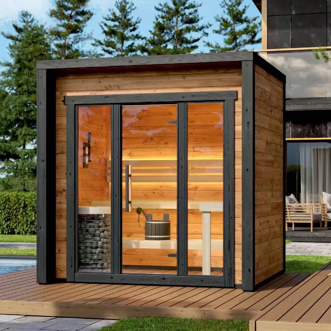 Modern outdoor sauna cabin with glass doors, wood interior, and black trim beside a pool