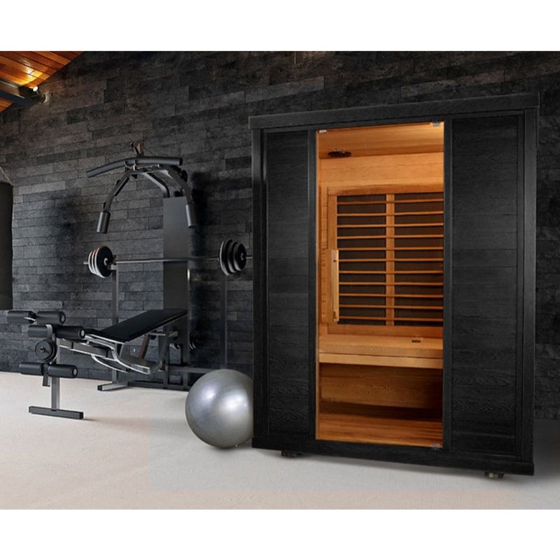 Modern home gym with a black sauna cabinet, workout bench,