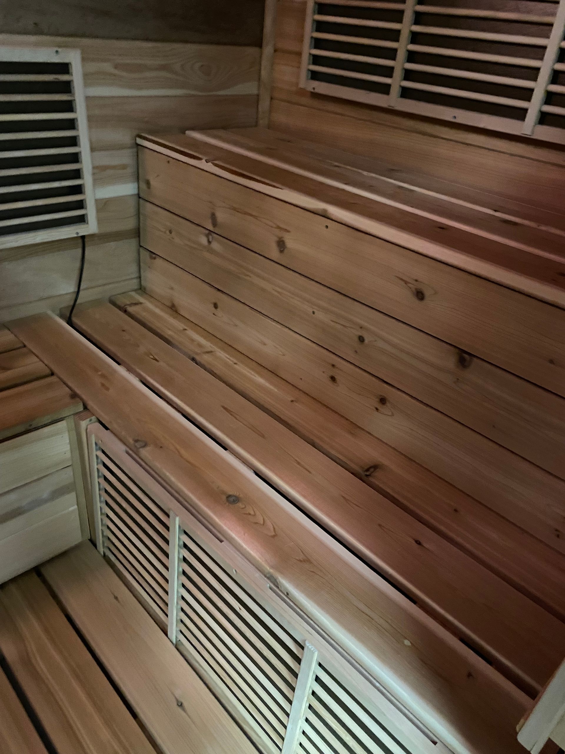 Wooden sauna benches with slatted vents and warm-toned wood panels