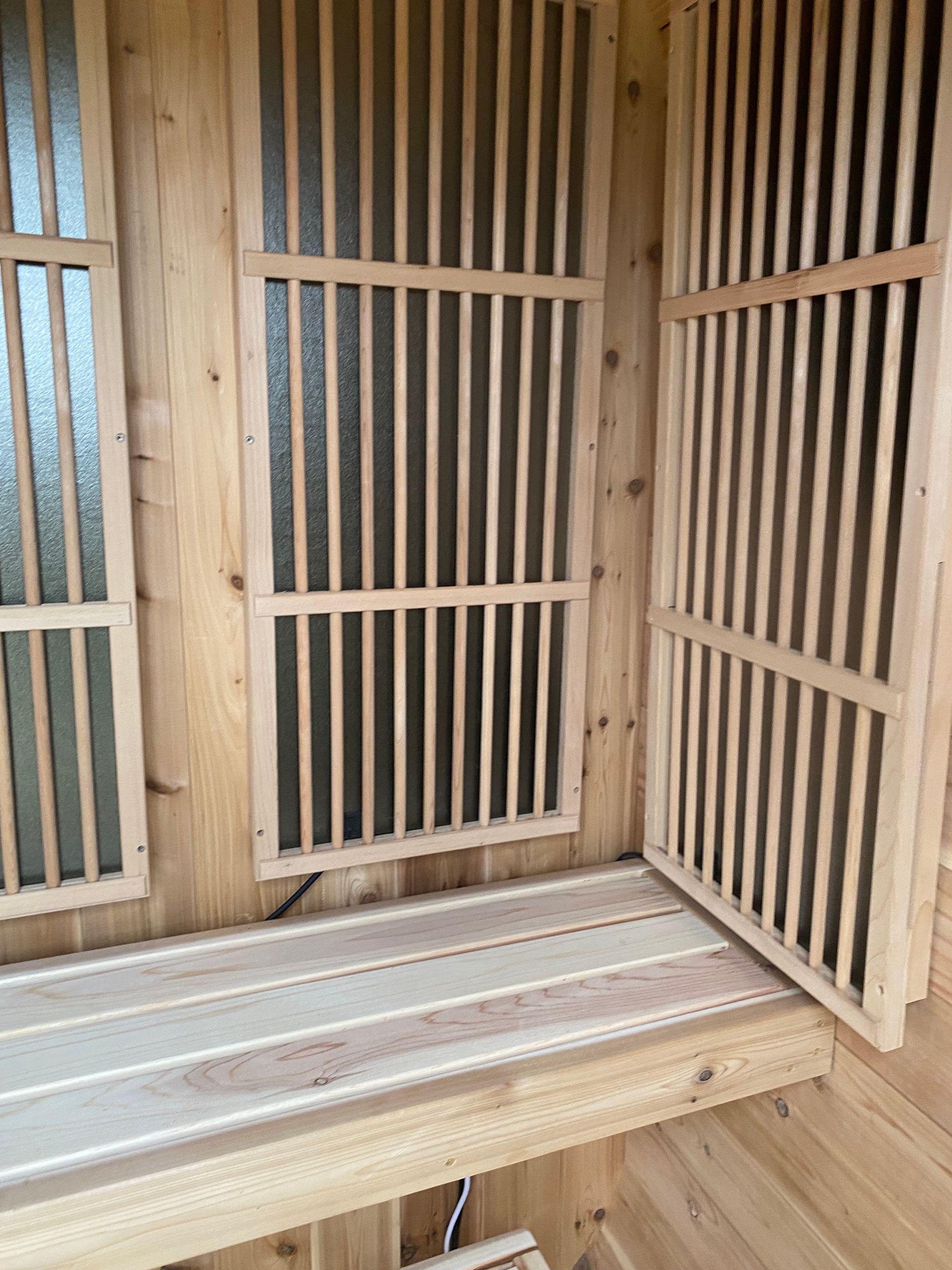 Wooden sauna interior with slatted benches and vertical wood-paneled walls